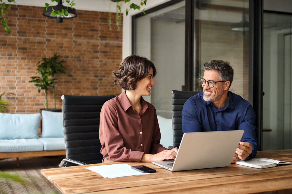 Business professionals reviewing cybersecurity support on a laptop